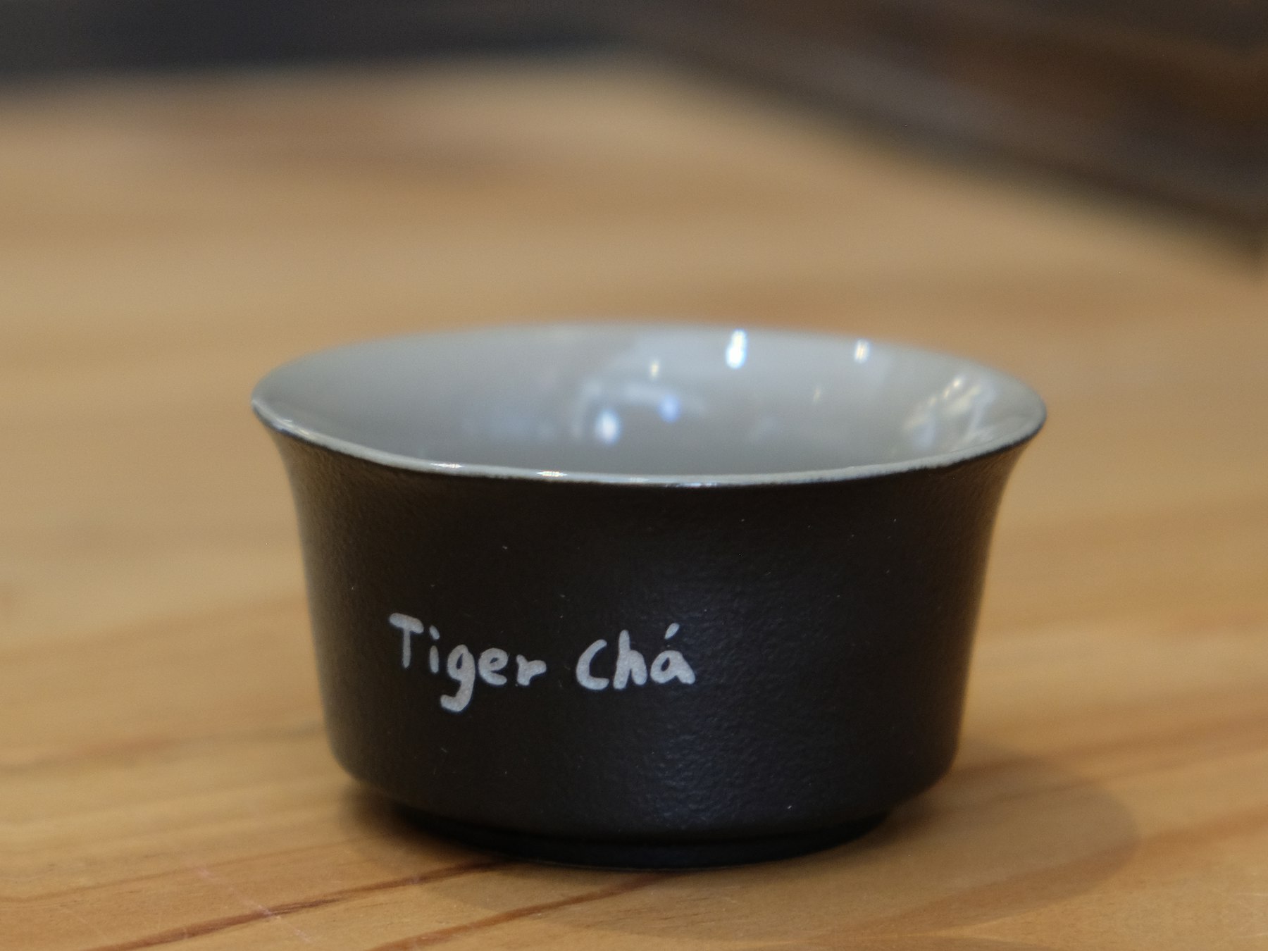 TigerCha teapot product photo with a wooden handle and laser logo.